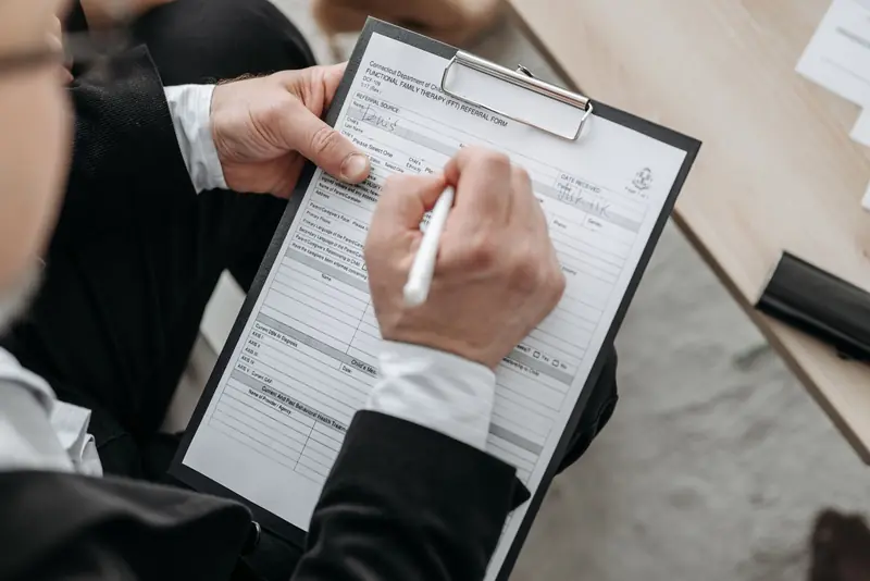 Someone filling in a form on a clipboard