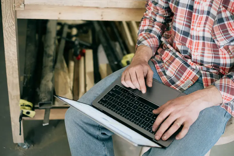 Someone working on a laptop in a workshop