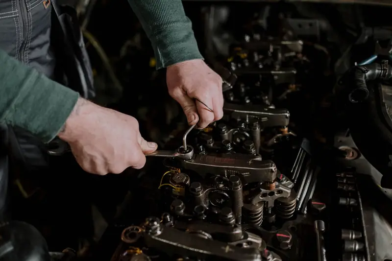 Hands working on an engine with a spanner