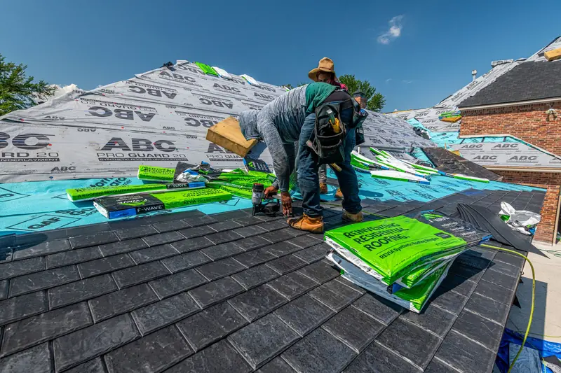 Roofers laying membrane on a house roof